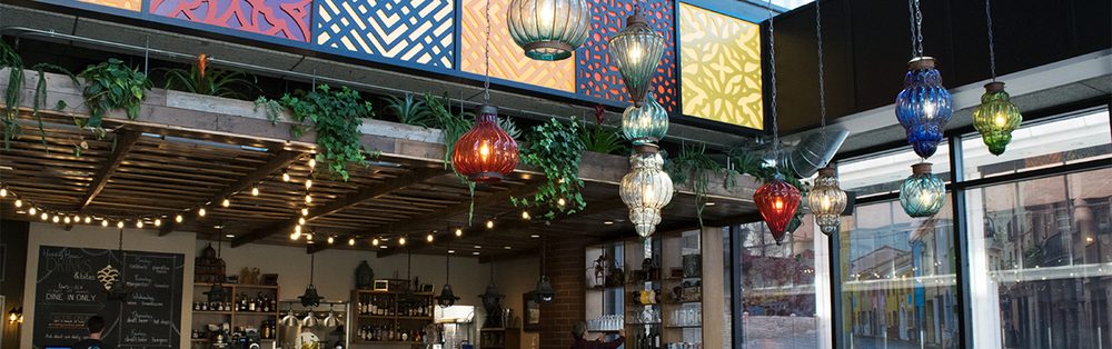 A wide view across the ROAM dining room with string lights, hanging coloured lanterns and chalkboard menus along the far wall.